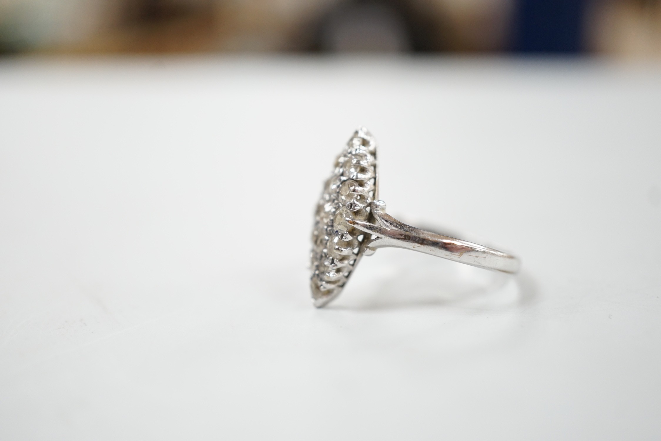 A mid 20th century 18ct white metal and diamond set marquise cluster ring, size P, gross weight 2.6 grams.